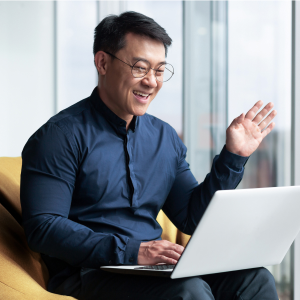 Photograph of a healthcare and life sciences sales rep waving on a video call